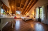 Charming attic bedroom with wooden beams, hardwood floors, and a cozy atmosphere.
