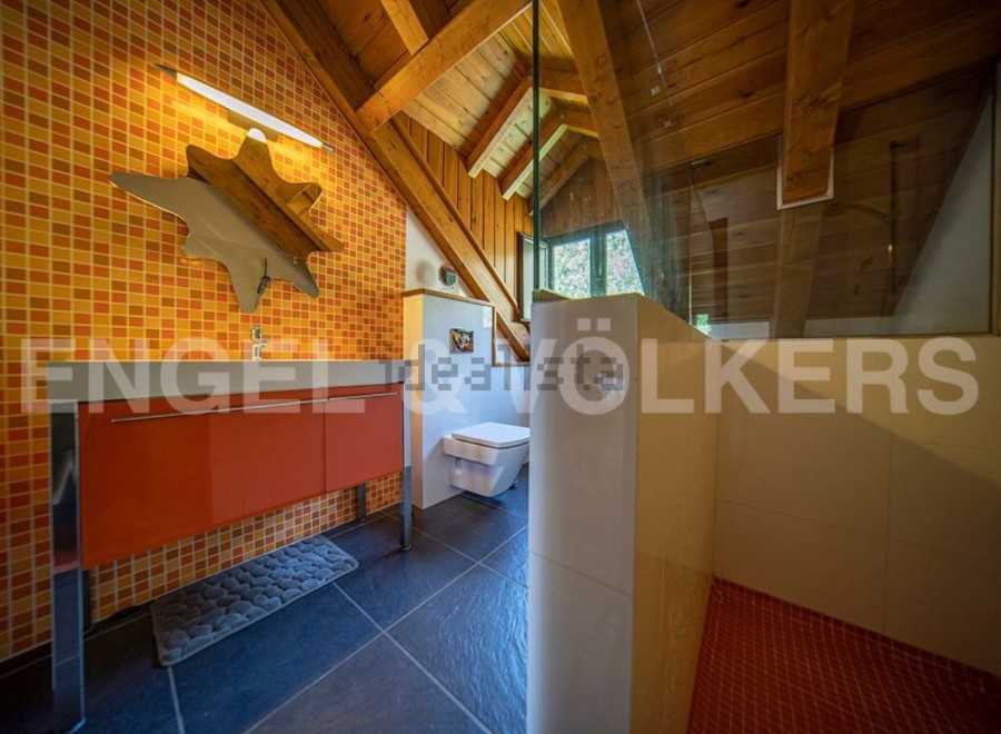 This stunning bathroom boasts a unique orange and white tile design, creating a vibrant and modern atmosphere.