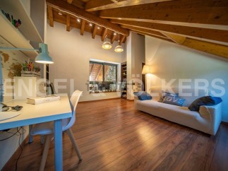 This attic room boasts a stunning wooden beam ceiling and large window, creating a bright and airy atmosphere.