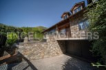 This stunning stone house boasts a spacious garage, a charming balcony, and large windows offering breathtaking views.