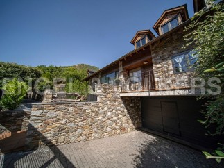 This stunning stone house boasts a spacious garage, a charming balcony, and large windows offering breathtaking views.