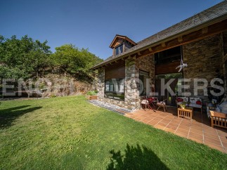 This stunning stone house boasts a spacious patio perfect for outdoor entertaining, surrounded by a lush green lawn.