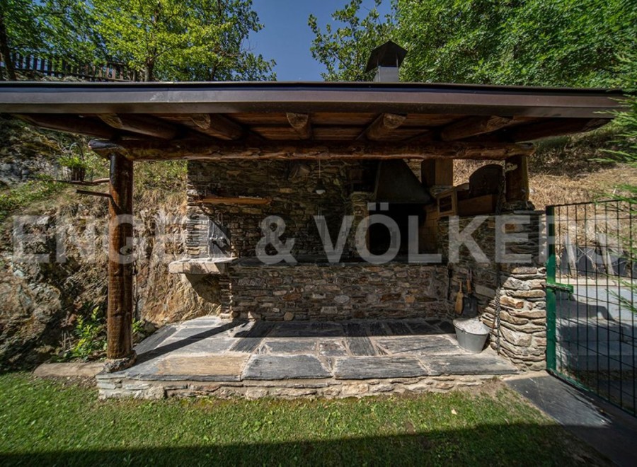 This stunning property boasts a charming outdoor kitchen and barbecue area, perfect for al fresco dining and entertaining.