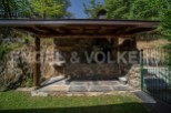 This stunning property boasts a charming outdoor kitchen and barbecue area, perfect for al fresco dining and entertaining.