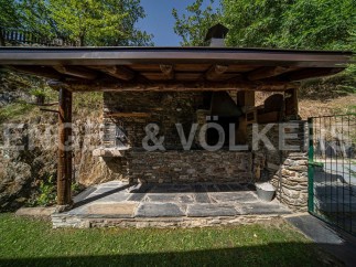 This stunning property boasts a charming outdoor kitchen and barbecue area, perfect for al fresco dining and entertaining.