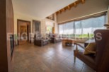 This stunning property boasts a spacious living area with large windows offering abundant natural light and views of the lush greenery.