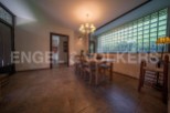 Charming dining area with rustic wooden table and chairs, complemented by a unique glass block window offering ample natural light.