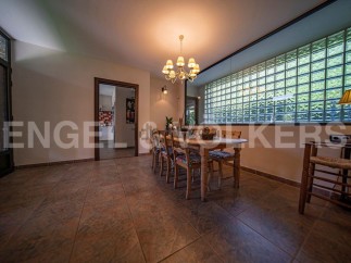 Charming dining area with rustic wooden table and chairs, complemented by a unique glass block window offering ample natural light.