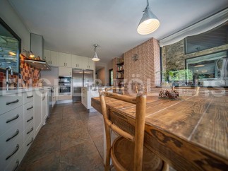 Rustic kitchen with wooden dining table and modern appliances.