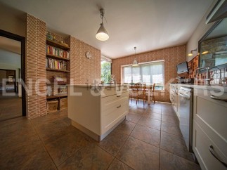 This stunning kitchen boasts a unique brick feature wall, custom cabinetry, and high-end appliances.