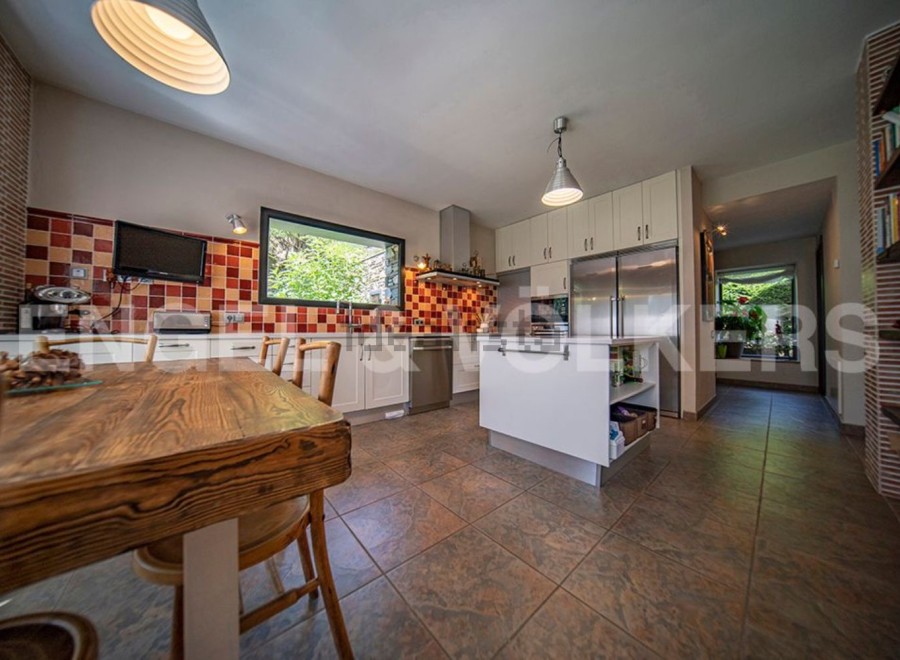 This stunning kitchen boasts a rustic wooden table, modern white cabinetry, and high-end stainless steel appliances.