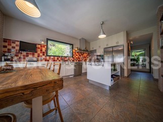 This stunning kitchen boasts a rustic wooden table, modern white cabinetry, and high-end stainless steel appliances.