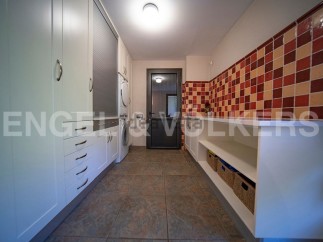 This stunning laundry room boasts ample storage with built-in cabinets and shelving, perfect for keeping everything organized.