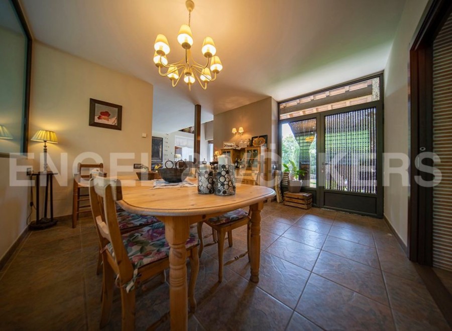 This charming dining room boasts a rustic wooden table, complemented by floral-patterned chairs and a warm, inviting atmosphere.