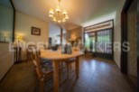 This charming dining room boasts a rustic wooden table, complemented by floral-patterned chairs and a warm, inviting atmosphere.