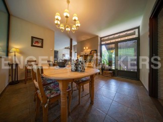 This charming dining room boasts a rustic wooden table, complemented by floral-patterned chairs and a warm, inviting atmosphere.