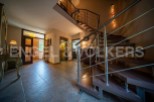 This stunning property boasts a spacious entrance hall with elegant tiled flooring, a modern elevator for convenient access, and a captivating spiral staircase leading to the upper levels.