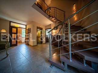 This stunning property boasts a spacious entrance hall with elegant tiled flooring, a modern elevator for convenient access, and a captivating spiral staircase leading to the upper levels.