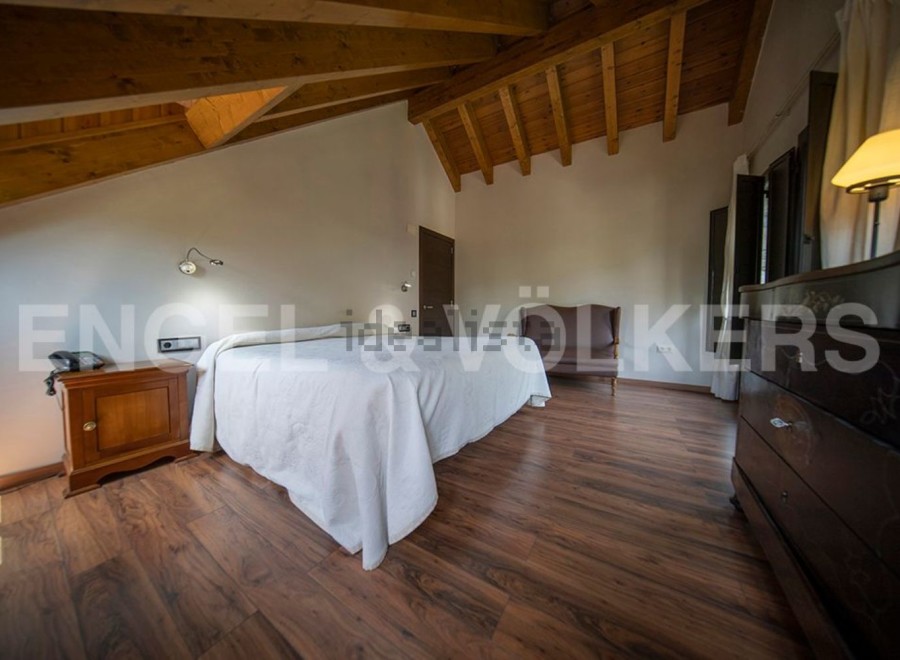 This stunning bedroom boasts a cozy wooden beamed ceiling and rich hardwood floors.
