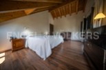 This stunning bedroom boasts a cozy wooden beamed ceiling and rich hardwood floors.