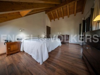 This stunning bedroom boasts a cozy wooden beamed ceiling and rich hardwood floors.