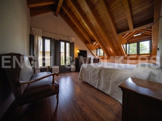 Charming attic bedroom with wooden beams, offering a cozy and rustic atmosphere.