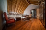 This stunning attic space boasts a beautiful wooden ceiling and hardwood floors, creating a warm and inviting atmosphere.