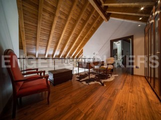 This stunning attic space boasts a beautiful wooden ceiling and hardwood floors, creating a warm and inviting atmosphere.