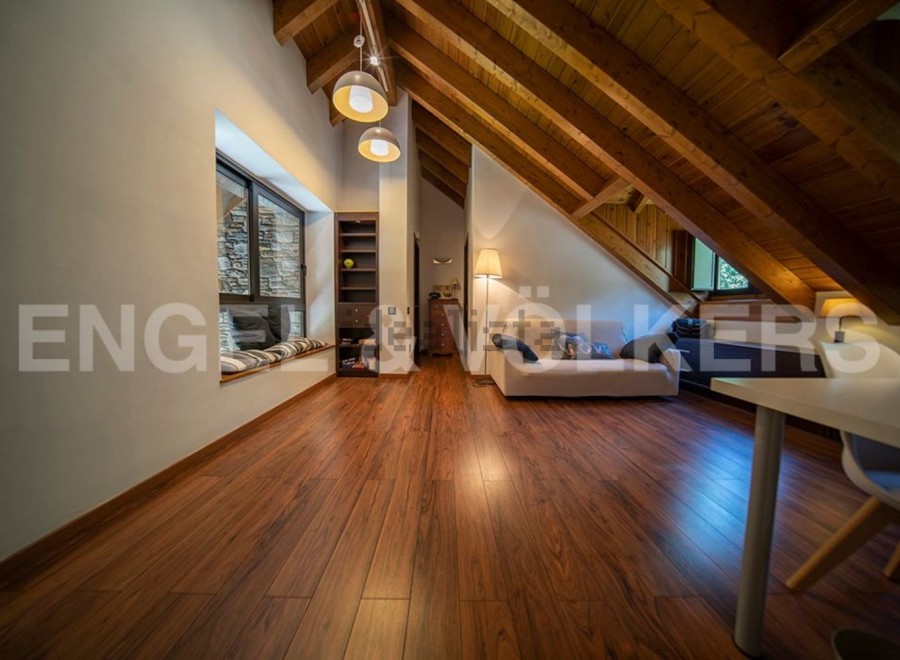 Stunning attic conversion boasts a spacious and bright open-plan layout with wooden beams and flooring.