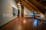 Stunning attic conversion boasts a spacious and bright open-plan layout with wooden beams and flooring.