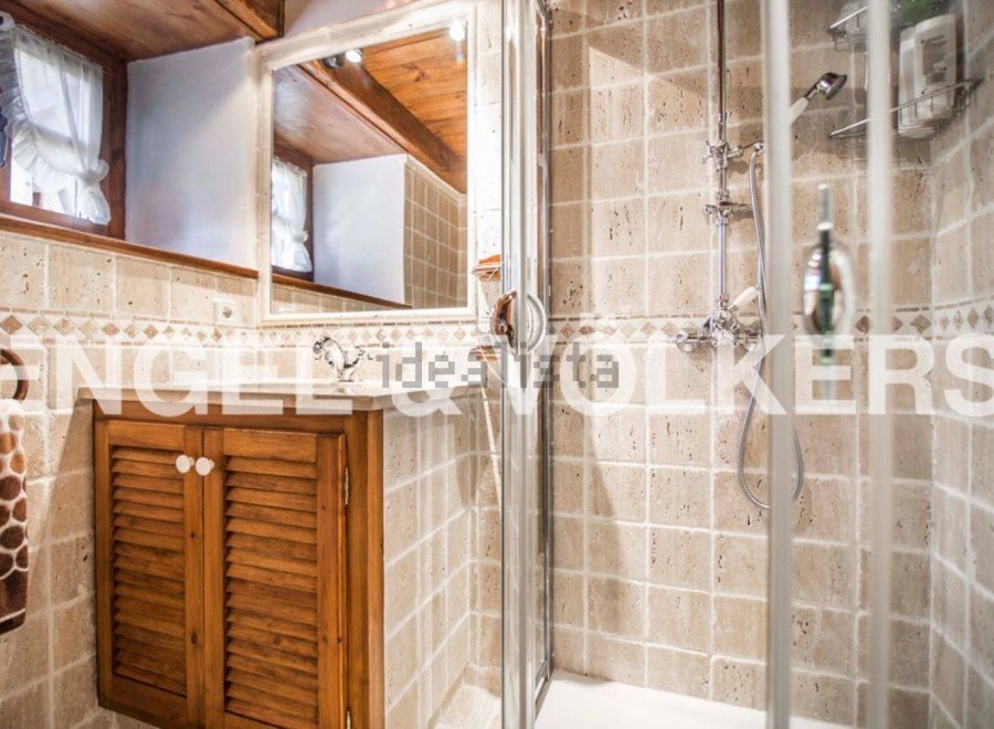 Charming bathroom with wooden cabinetry and beige tile.