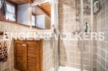 Charming bathroom with wooden cabinetry and beige tile.