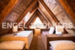 Charming attic bedroom with exposed wooden beams and built-in storage.