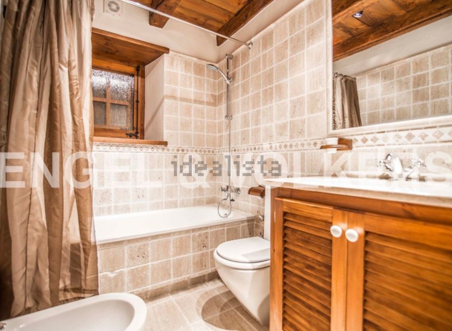 Charming bathroom with wooden accents and tiled walls.