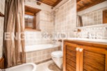 Charming bathroom with wooden accents and tiled walls.
