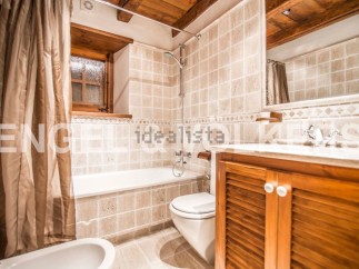 Charming bathroom with wooden accents and tiled walls.