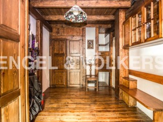 This charming chalet boasts a rustic interior with exposed wooden beams and floors, creating a warm and inviting atmosphere.