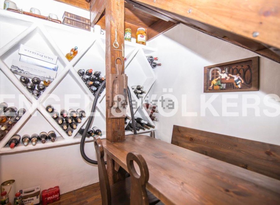 This charming property boasts a unique wine cellar, complete with built-in wooden racks and a rustic wooden table perfect for wine tasting.