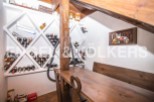 This charming property boasts a unique wine cellar, complete with built-in wooden racks and a rustic wooden table perfect for wine tasting.