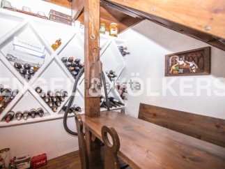 This charming property boasts a unique wine cellar, complete with built-in wooden racks and a rustic wooden table perfect for wine tasting.