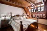Charming attic bedroom with wooden beams and sloped ceilings.
