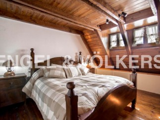 Charming attic bedroom with wooden beams and sloped ceilings.