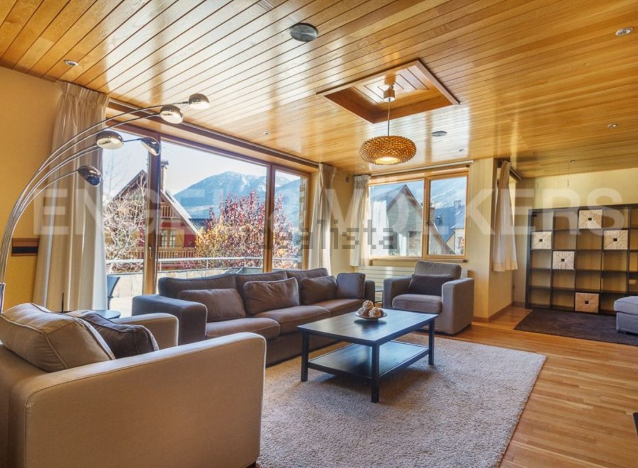 This stunning apartment boasts a spacious living area with floor-to-ceiling windows offering breathtaking mountain views.