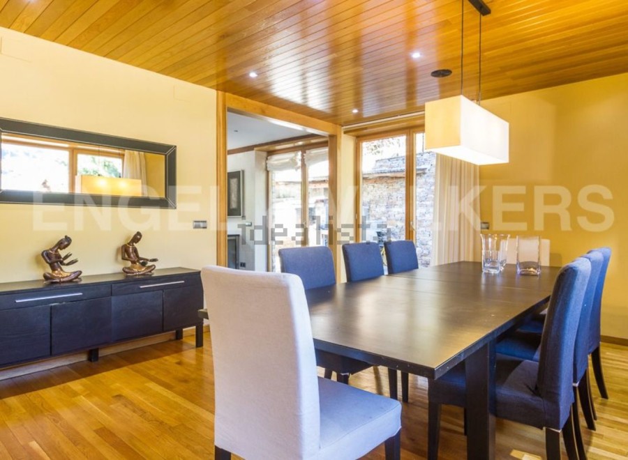 This stunning dining room boasts a sleek, modern design with hardwood floors and a wood-paneled ceiling.