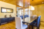This stunning dining room boasts a sleek, modern design with hardwood floors and a wood-paneled ceiling.