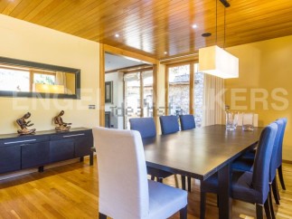 This stunning dining room boasts a sleek, modern design with hardwood floors and a wood-paneled ceiling.
