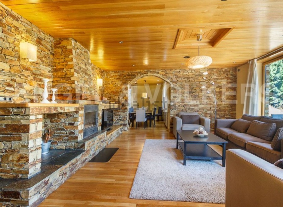 This stunning chalet boasts a spacious living area with a cozy fireplace, perfect for relaxing after a day on the slopes.