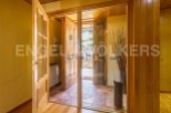 This stunning property boasts a grand entrance with rustic wooden doors, creating a warm and inviting atmosphere.