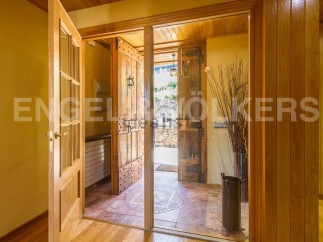 This stunning property boasts a grand entrance with rustic wooden doors, creating a warm and inviting atmosphere.