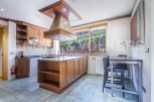 This stunning kitchen boasts a large island with granite countertops and ample wooden cabinetry, perfect for both cooking and entertaining.